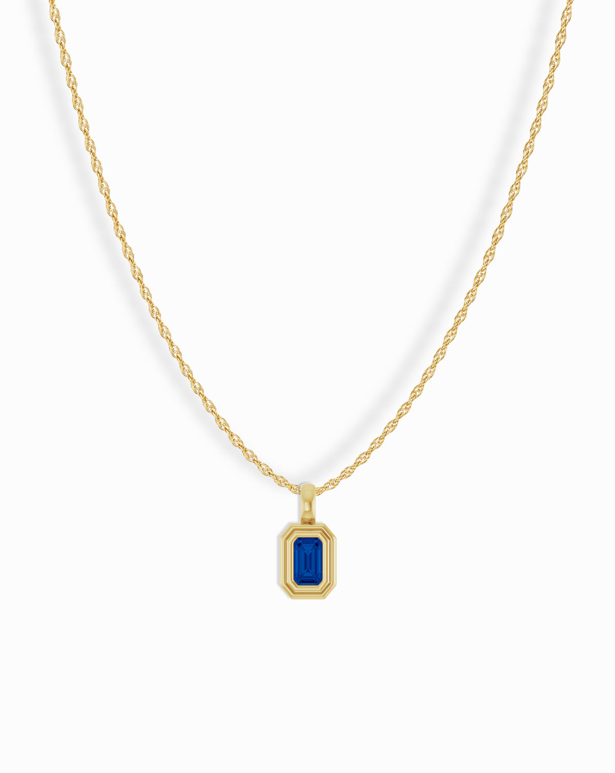 Mod + Jo 14k Birthstone Pendant Necklace featuring a gold rope chain and a rectangular blue emerald-cut stone in a stepped bezel setting.