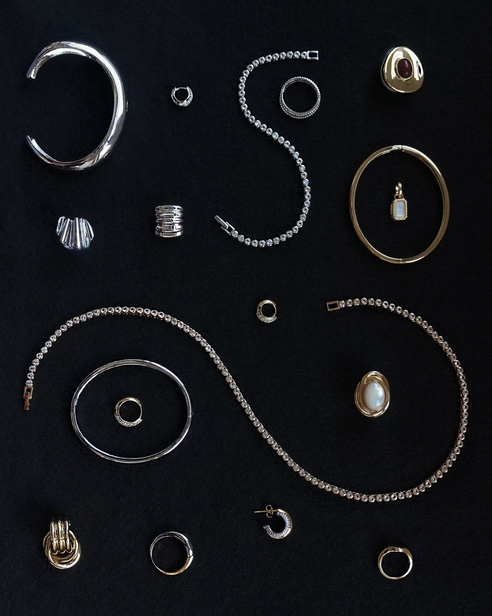 Collection of various jewelry items including rings, necklaces, and earrings on a black background