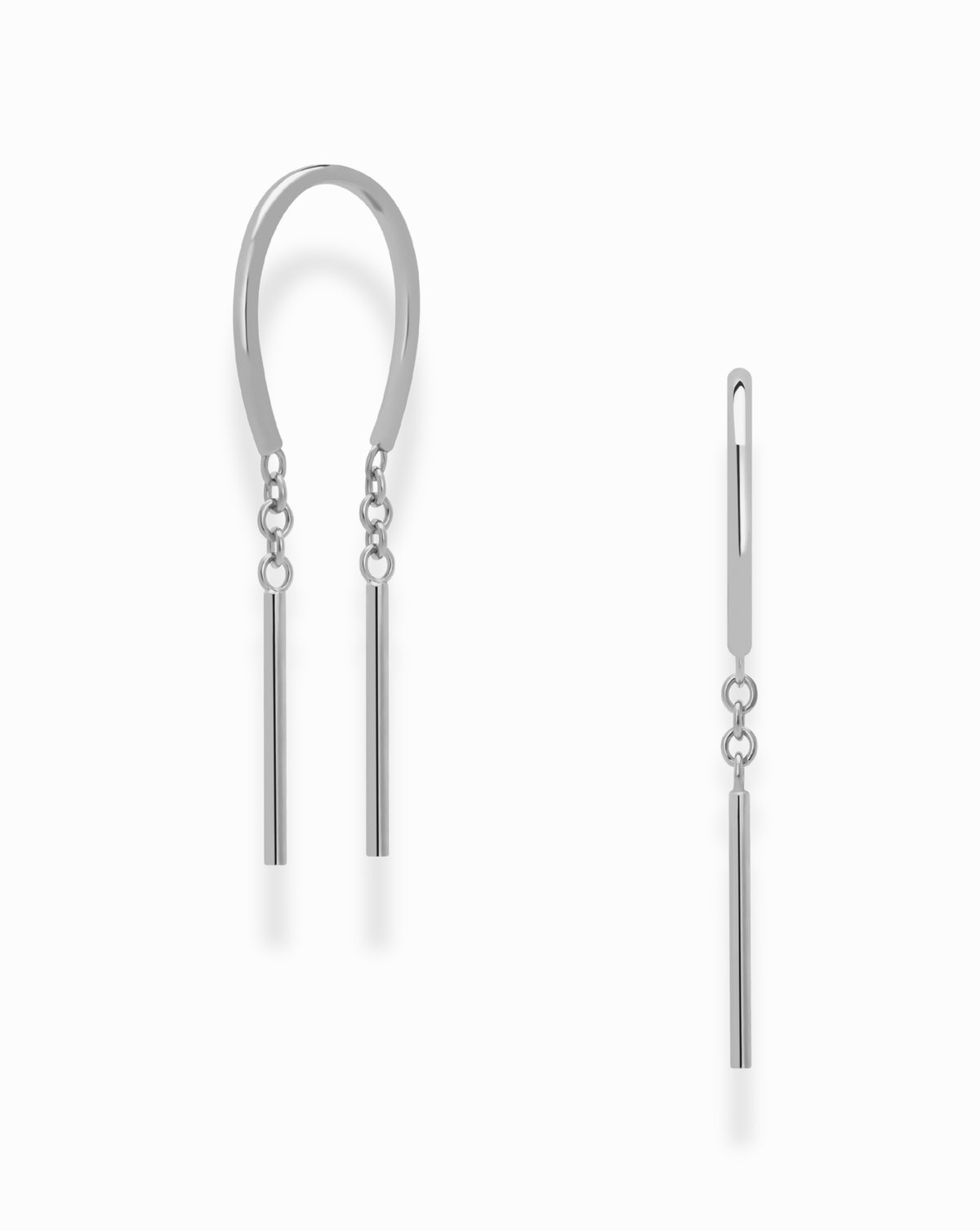 Introducing the Mila Smooth Threader Huggies by Mod + Jo: this set features two minimalist silver earrings—a curved hoop-like huggie with two sleek vertical bars, and a straight threader earring adorned with a single bar suspended from a short chain. Crafted from nickel-free materials for comfortable, everyday wear, both pieces showcase a modern design against a crisp white background.