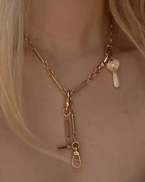 Gold necklace with charms on a person's neck