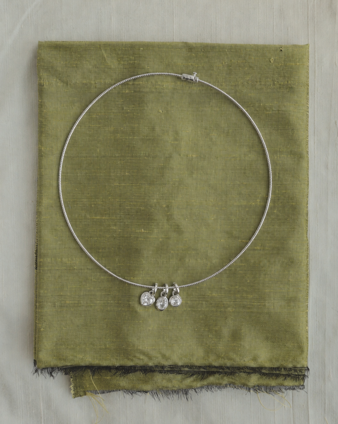 Celine Collar Necklace in silver, featuring a rigid design with three small, circular and heart-shaped sapphire charms.