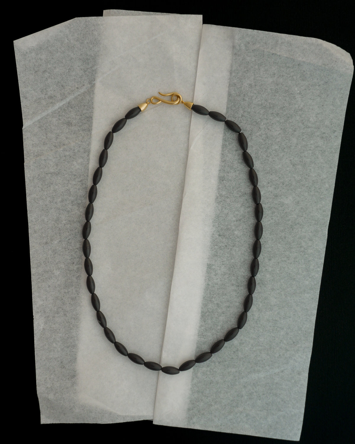 Sutton Gemstone Necklace featuring an 18-inch strand of small, dark, rice-shaped black agate beads with a gold-tone hook clasp.