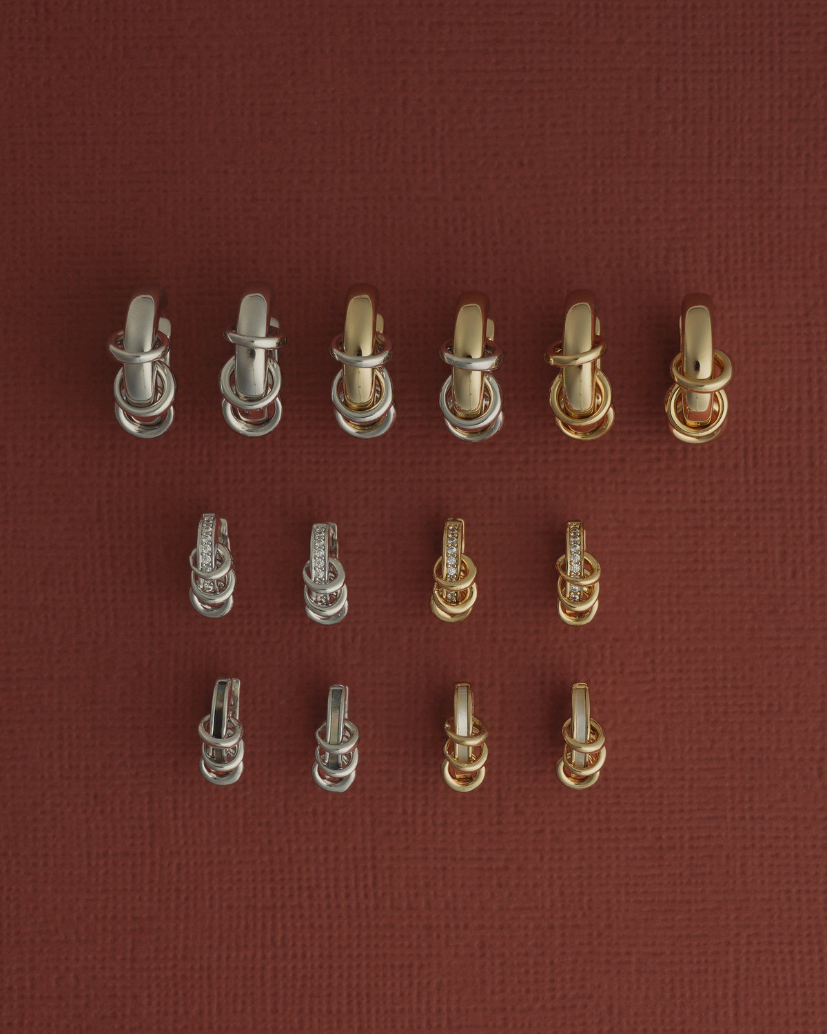Three rows of Levi Huggies Gift Set earrings featuring gold and silver tone huggies with attached linked rings, some accented by small stones.