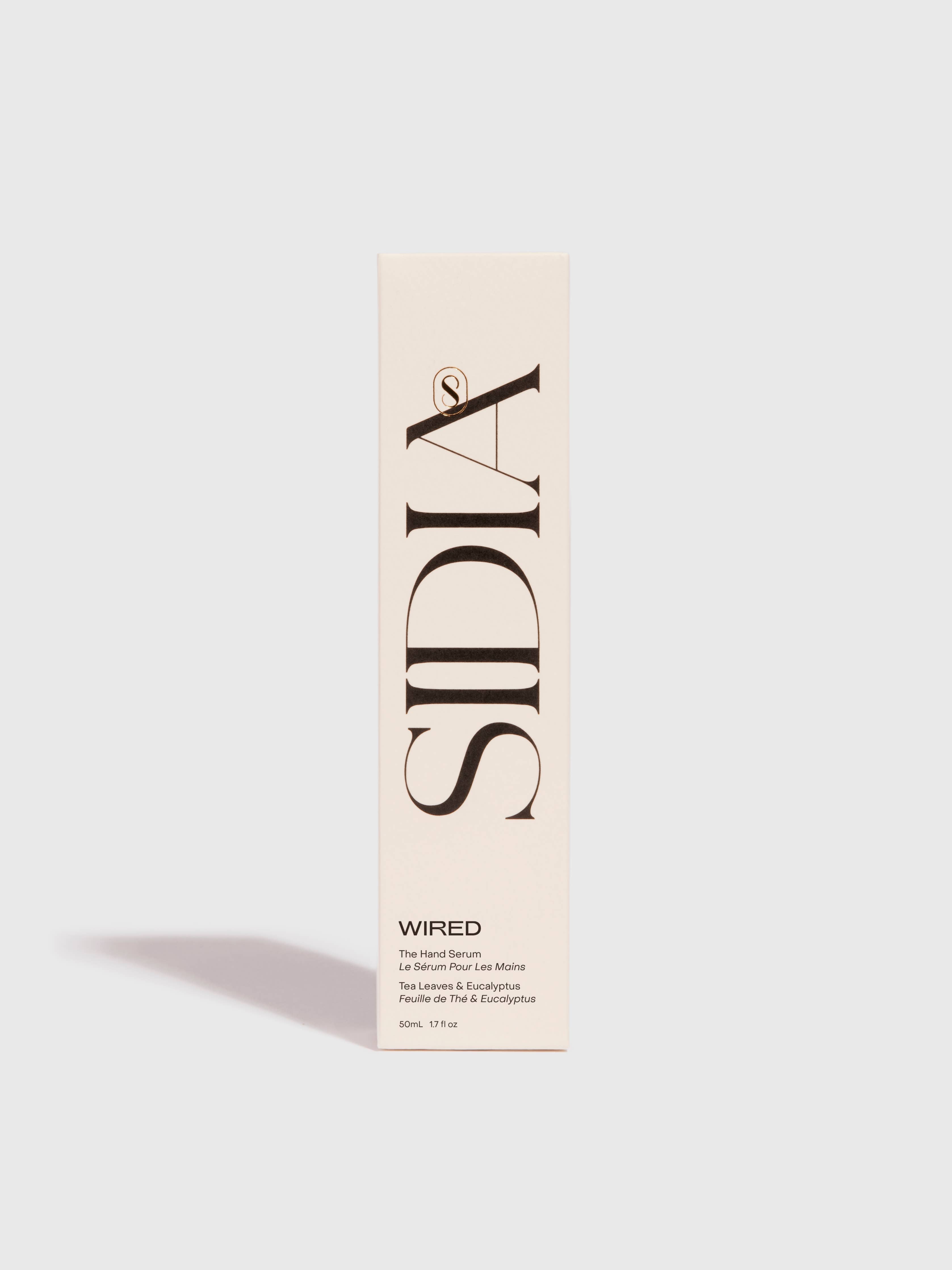 A cream-colored rectangular box stands upright, featuring large vertical black "SIDIA" branding. At the bottom, it reads "WIRED" and notes The Hand Serum by SIDIA—a lightweight, fast-absorbing hand serum—against a plain light background.