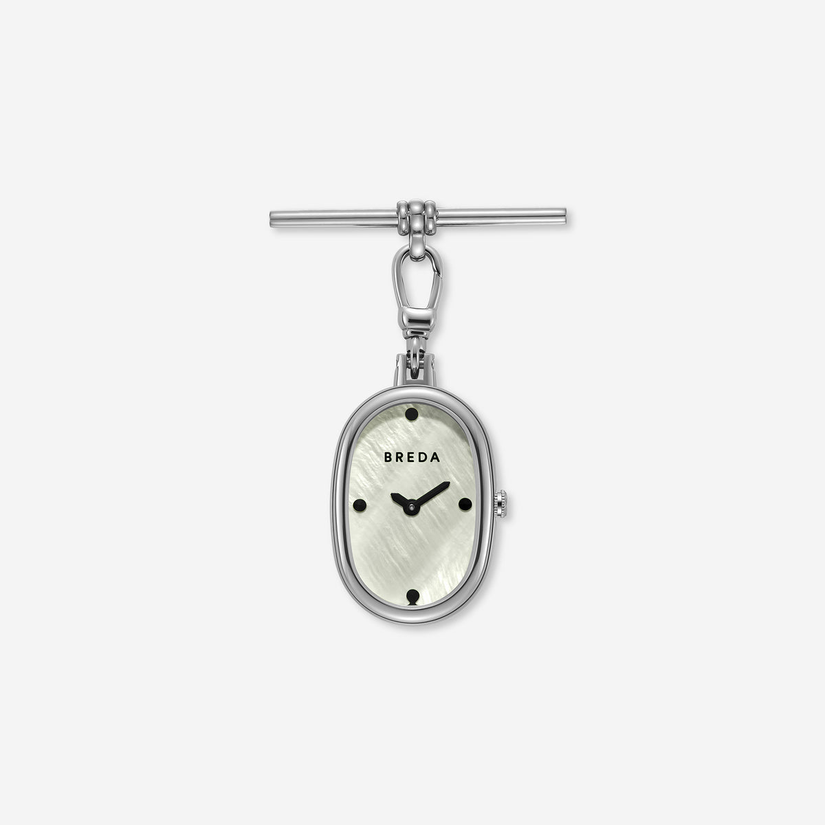 The Jane Time Charm by BREDA showcases a silver oval pocket watch featuring a white textured face, black hour markers, and Breda branding, elegantly attached to a T-bar clasp—all set against a plain white background.