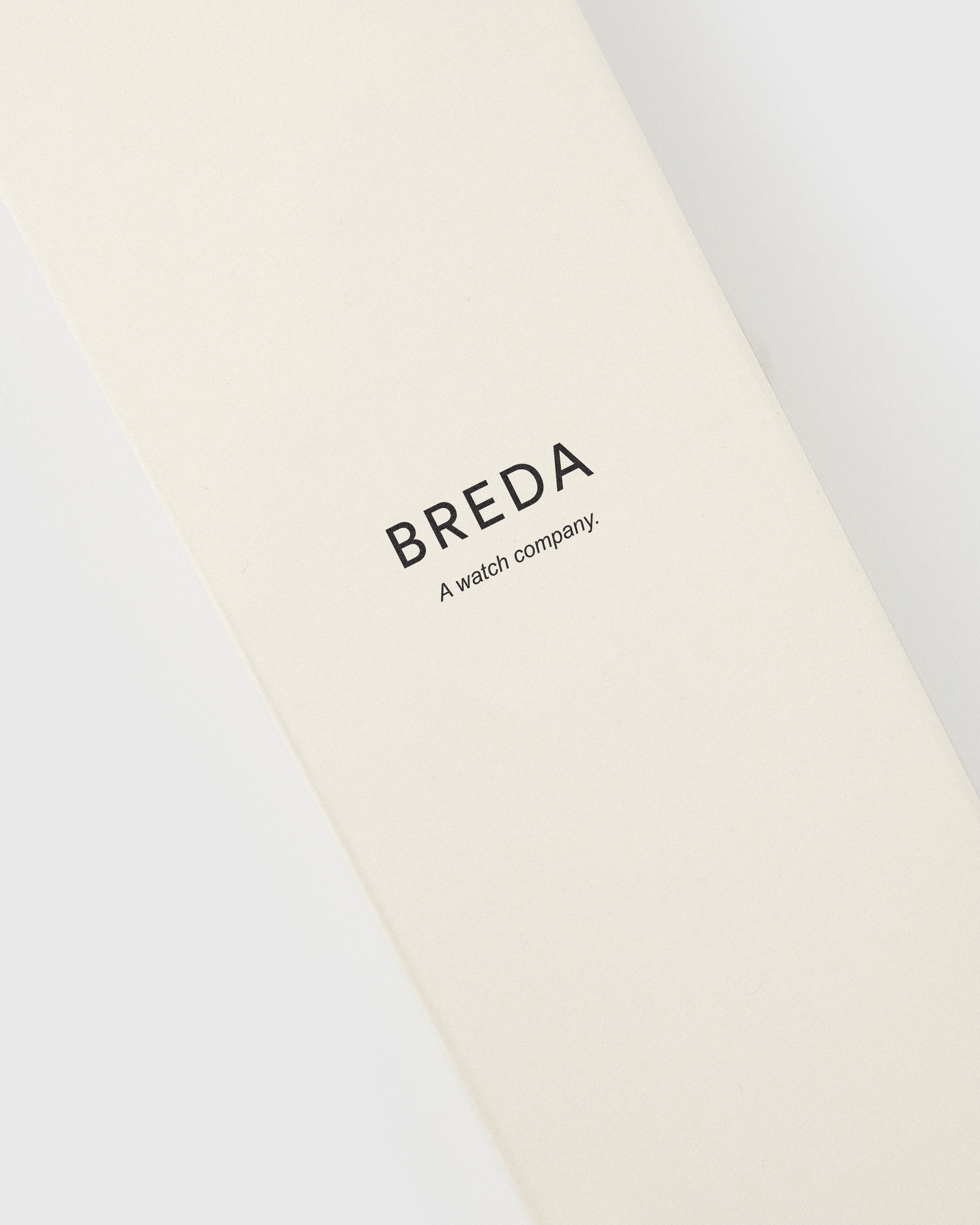 Beige strap with 'BREDA' branding on a white background