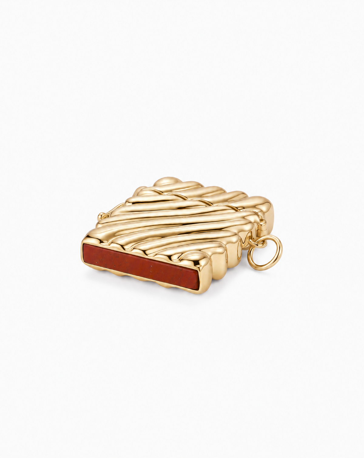Caspia Vesta Case Charm: a rectangular gold-plated charm with a ribbed surface, a red jasper inlay on the side, and a small jump ring attached to the edge.