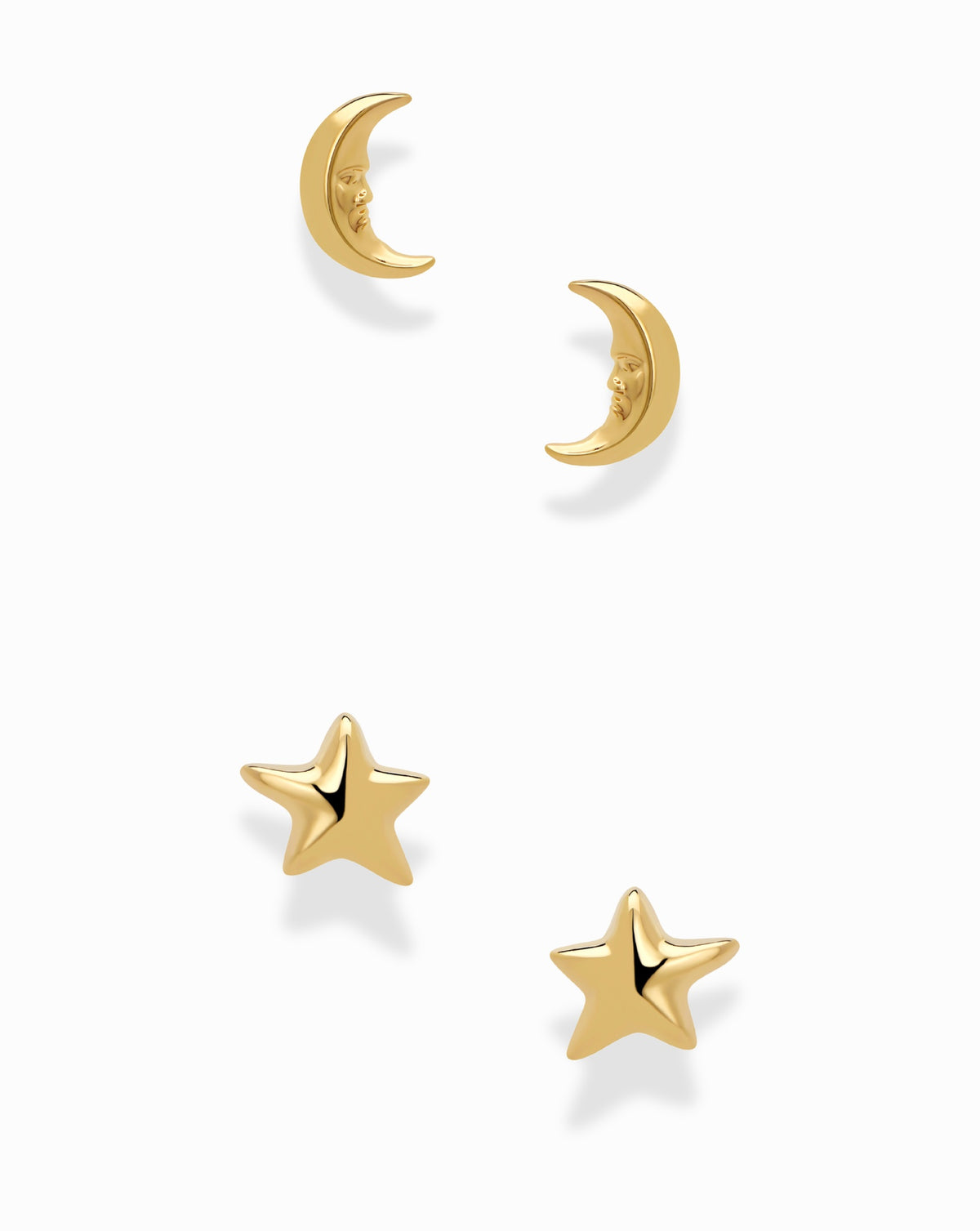 Mod + Jo Celestial Studs set featuring two gold moon stud earrings with faces and two matching star stud earrings.