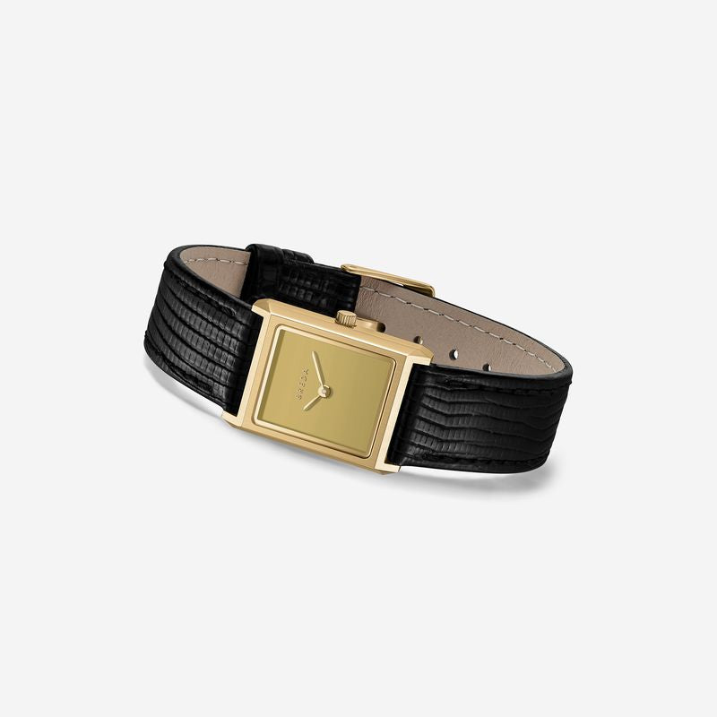 The Virgil Watch Small (Lizard Embossed) by Breda features a rectangular gold face, black hour and minute hands, and a textured black lizard-embossed band, displayed on a light gray background.