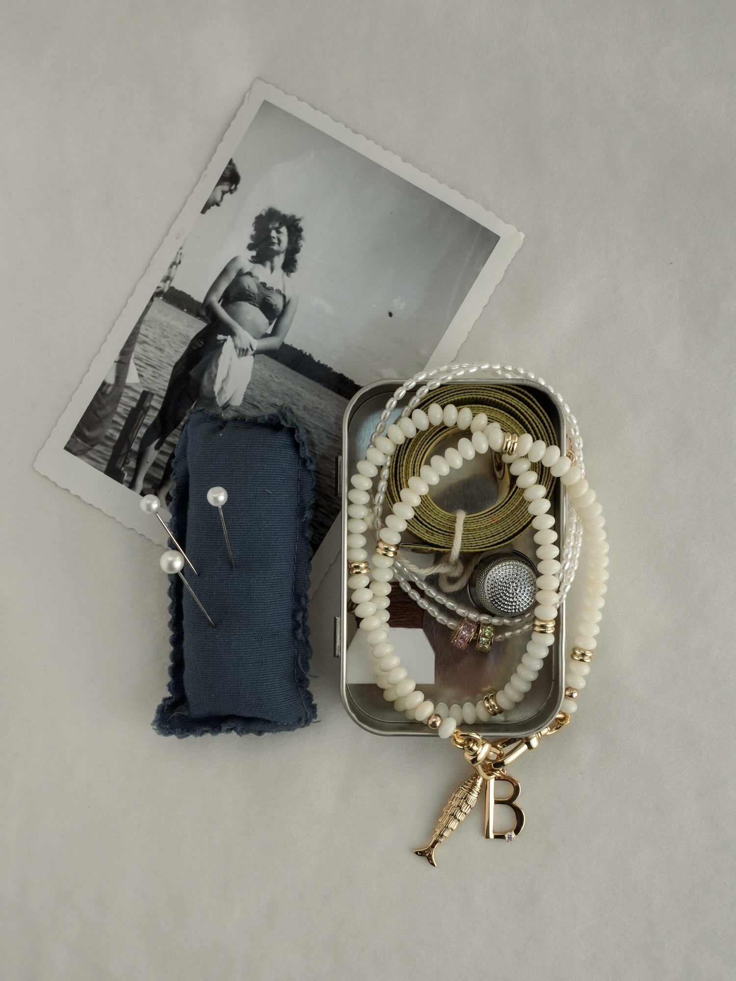 Jewelry set with a blue pouch, gold chain, and necklace on a gray surface.