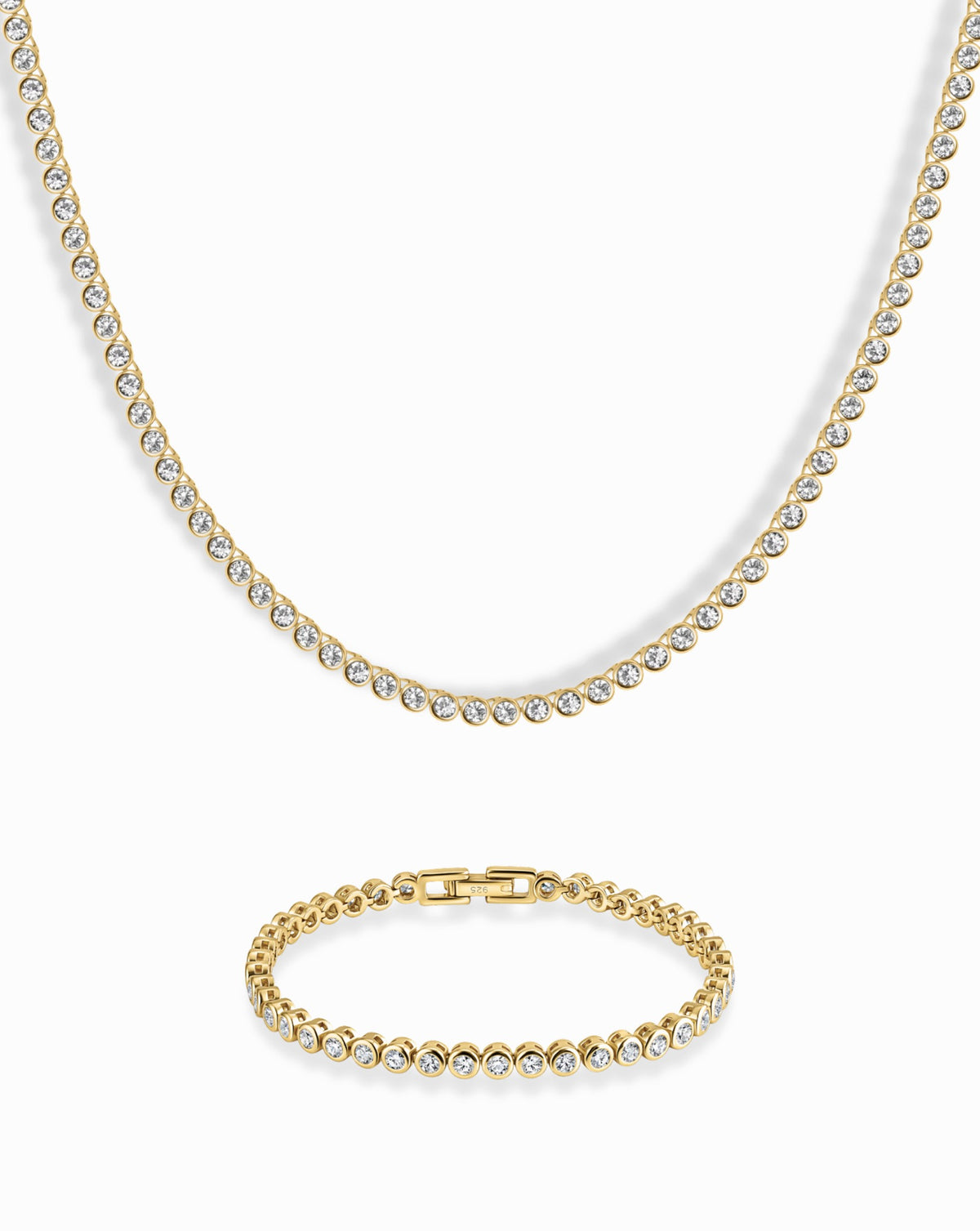Emma Set featuring a gold-toned bezel tennis necklace and matching bracelet, both with a continuous row of round clear stones in bezel settings.