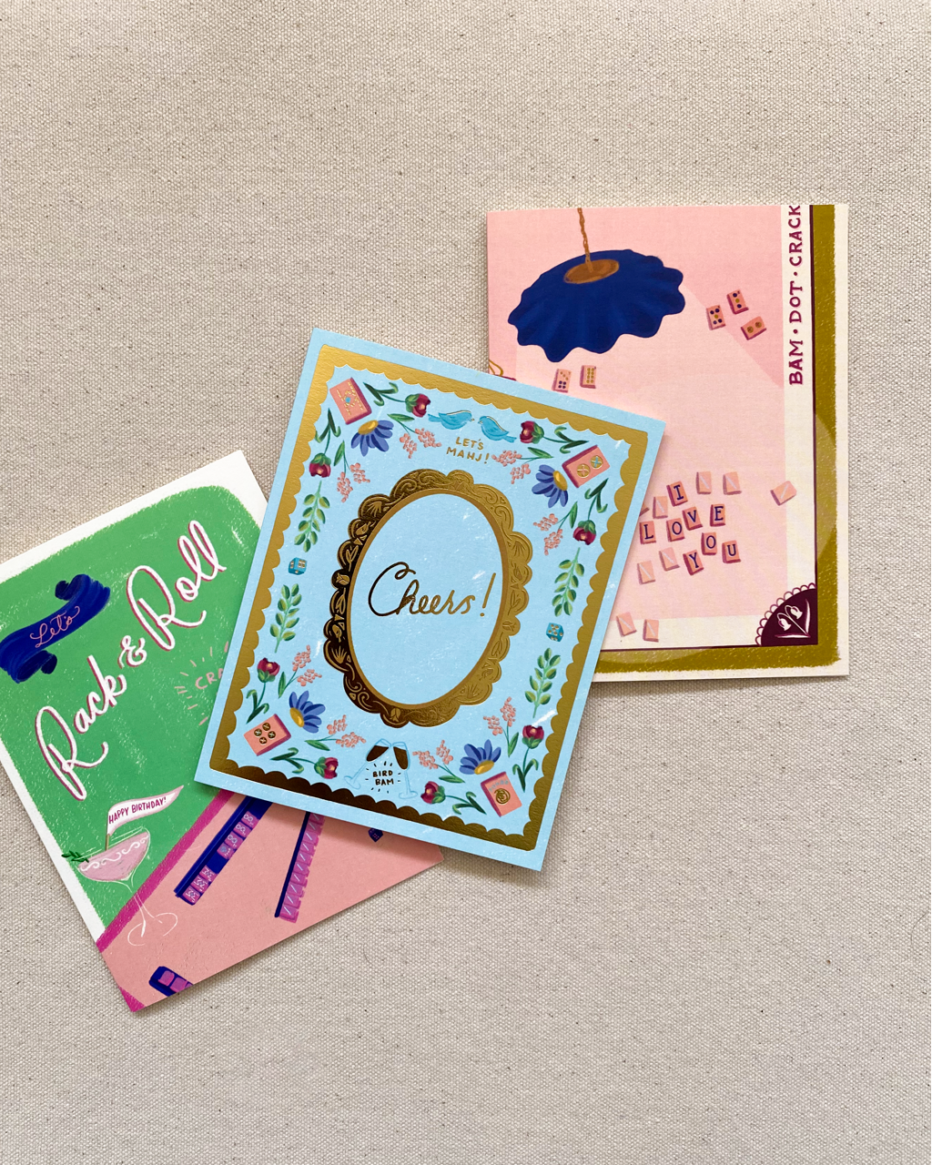 Three colorful greeting cards on a textured surface