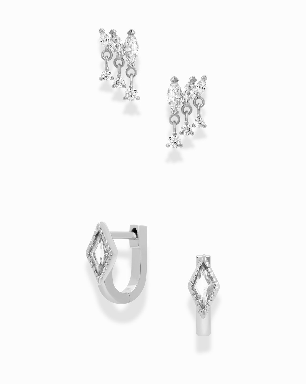 Mod + Jo Gabby + Phoebe Set featuring two pairs of silver earrings: marquise dangle studs hanging in a cluster and kite huggies with a diamond-shaped stone.