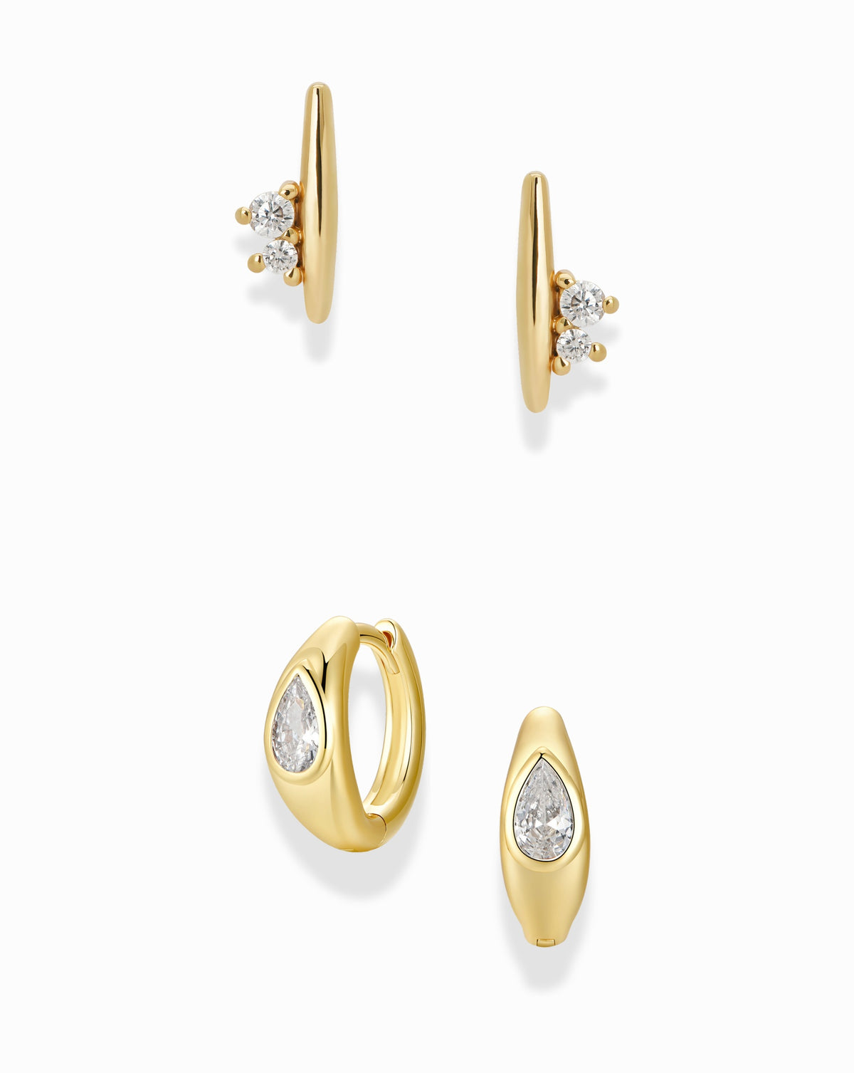 The Ida + Tally Set by Mod + Jo includes two pairs of gold hoop earrings: one pair of stone cluster earrings, and the other featuring a pear huggie hoop design with a single teardrop-shaped crystal.