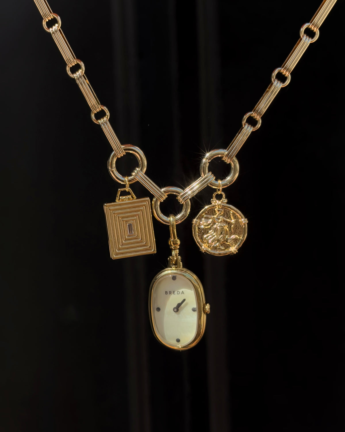 Mod + Jo Jagger Charm Clip Necklace in 14k gold featuring a ball chain, a rectangular charm, a circular relief charm, and an oval watch face pendant.