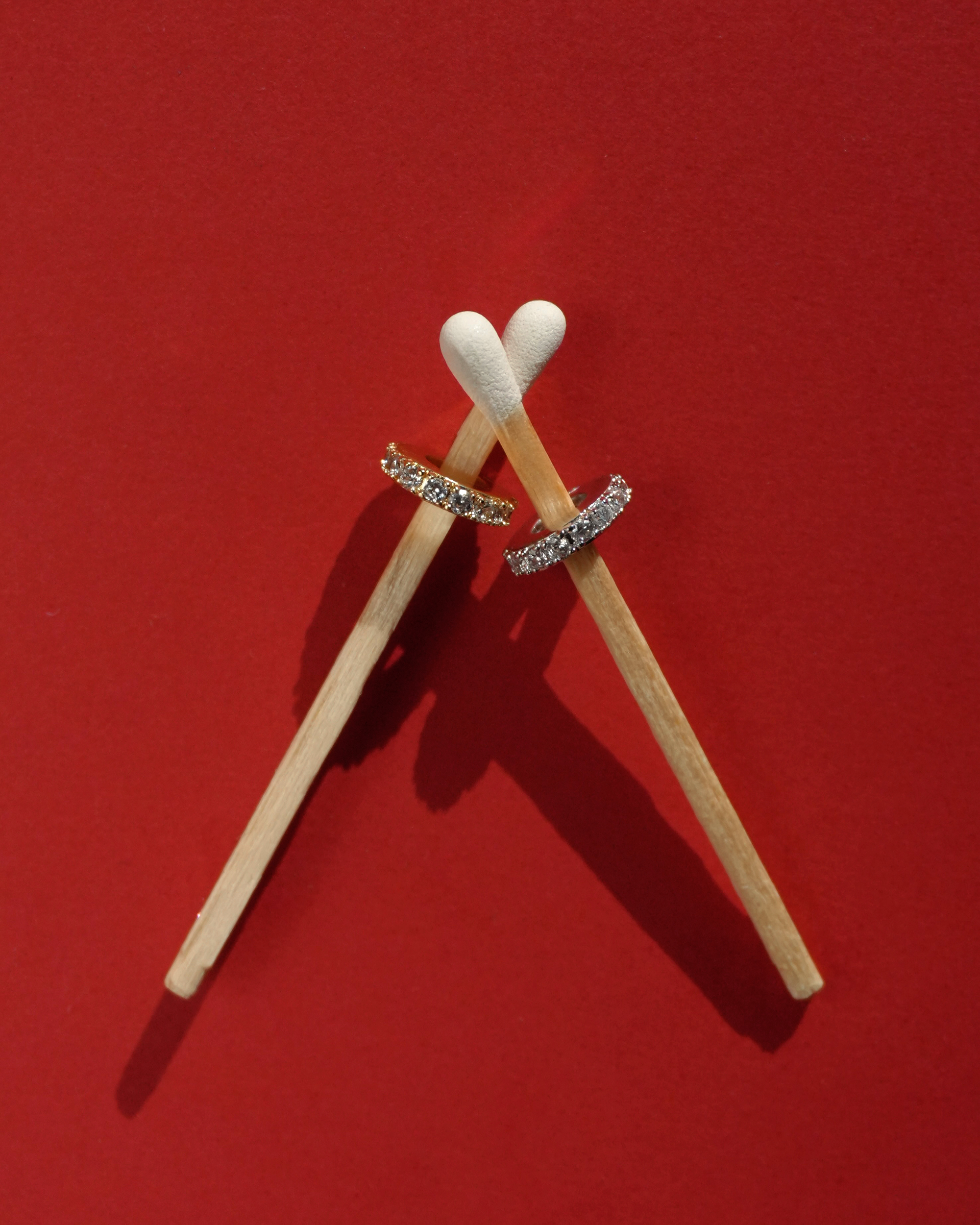Two pave charm spacers on matches against a red background