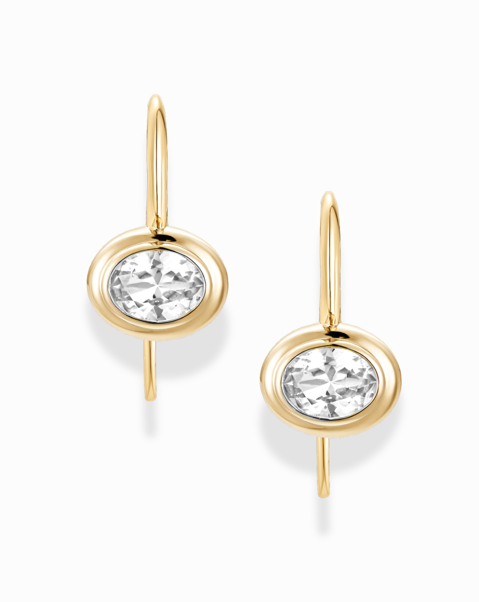 Gold earrings with white sapphire gemstones on a white background