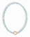 The Macey Gemstone Necklace by Mod + Jo features round, light blue marbled beads and a standout round gold clasp at the front.