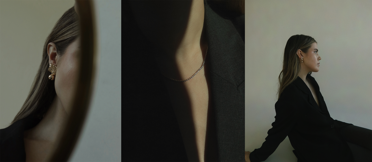 Three artistic portraits show a woman in a black blazer: left, close-up of her ear with gold earrings; center, close-up of her neck with a thin chain necklace; right, side view of her sitting against a plain wall.
