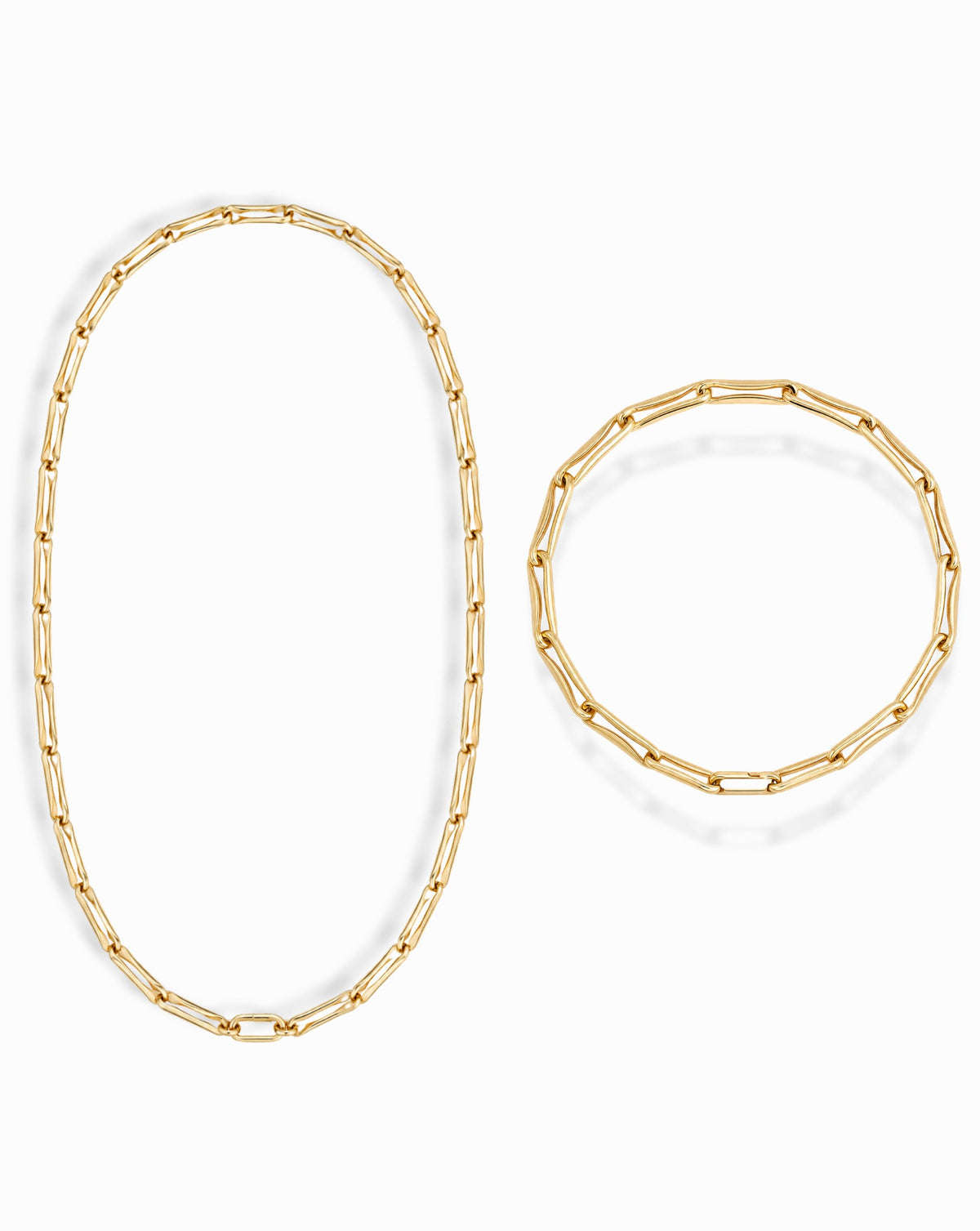The Molly Set features a gold elongated link chain necklace and matching bracelet made of rectangular links.