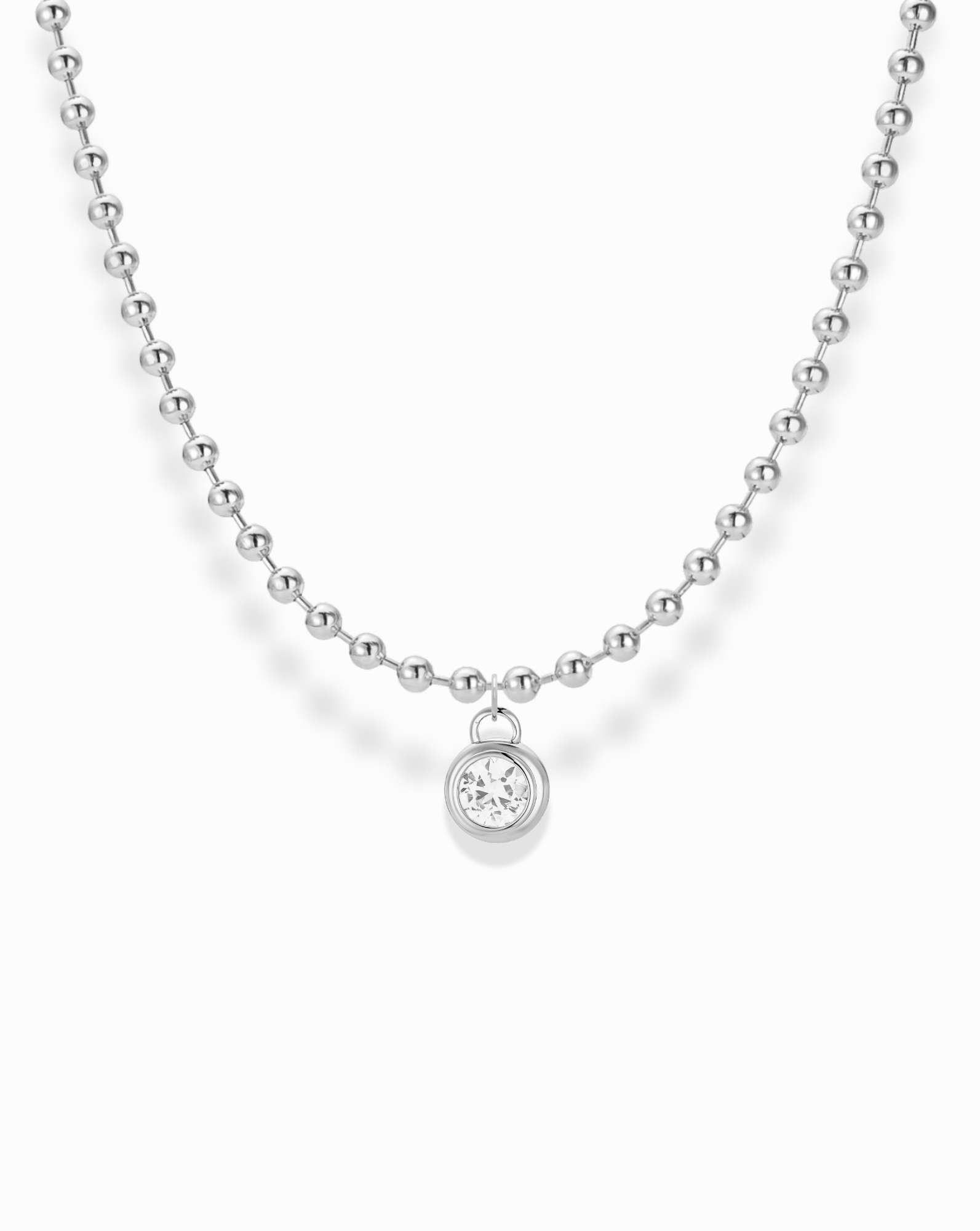 The Soren Bezel Pendant Necklace is a silver beaded chain featuring a round, lab-grown white sapphire set in a simple bezel with a clear, faceted gemstone pendant.