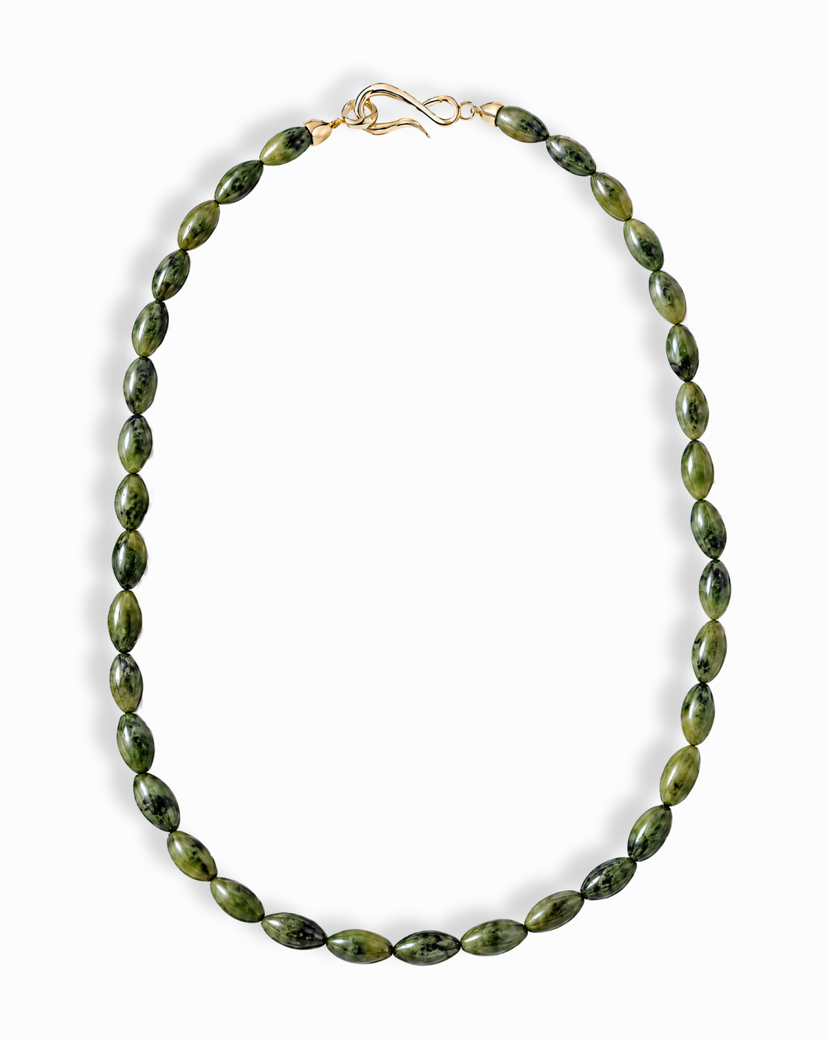 Sutton Gemstone Necklace featuring an 18″ strand of rice-shaped, mottled green serpentine jade beads secured with a gold clasp.