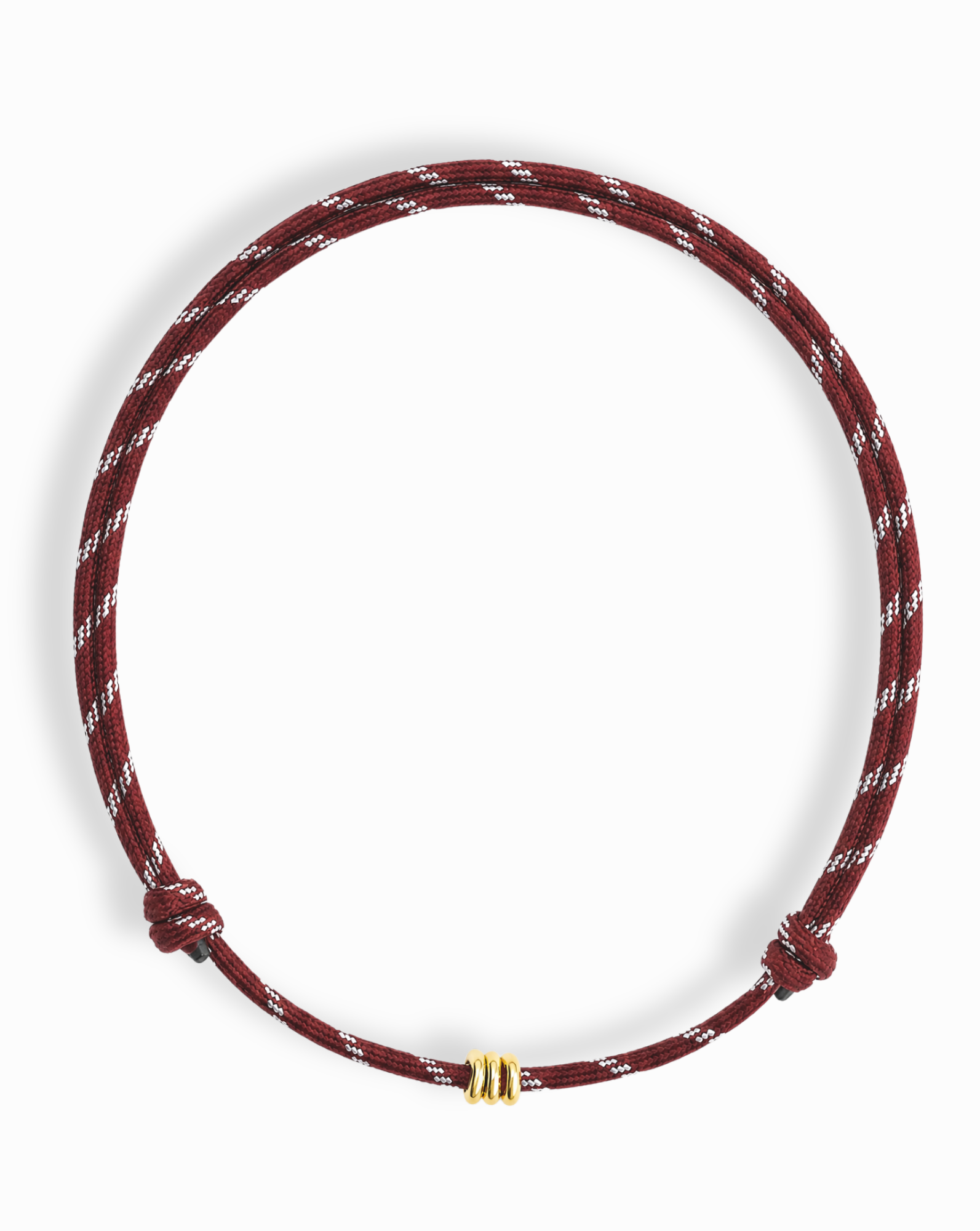 The Mod + Jo Tommy Cord Necklace is a maroon and white braided paracord accessory, featuring two knots and a small gold plate accent bead at the center, shown against a white background.