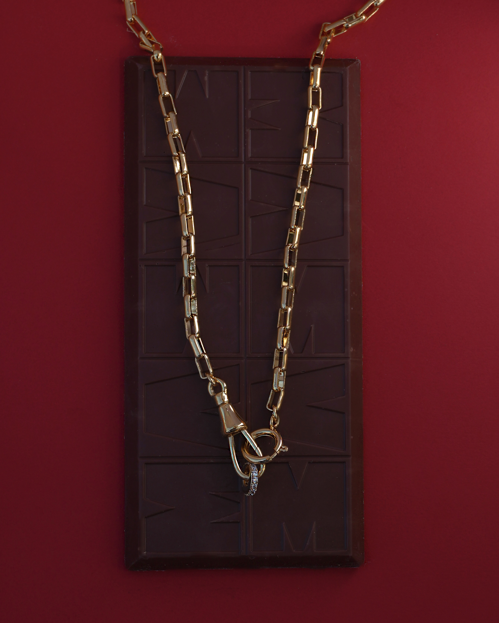 gold chain necklace draped over a chocolate bar
